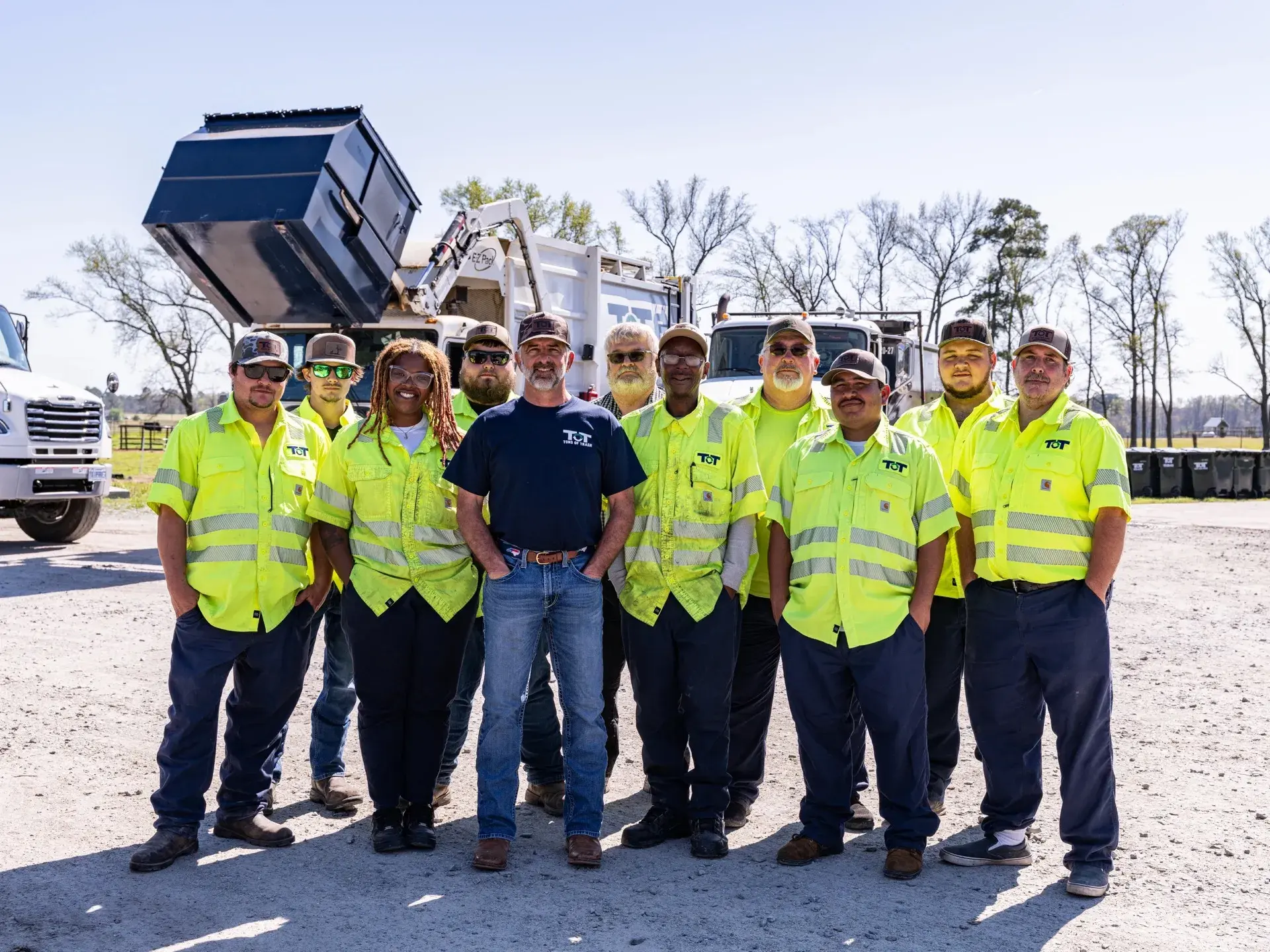 The Tons of Trash crew standing together in front of their fleet in eastern North Carolina